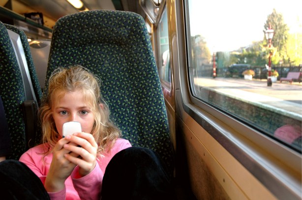 Girl using a mobile phone while on a train.